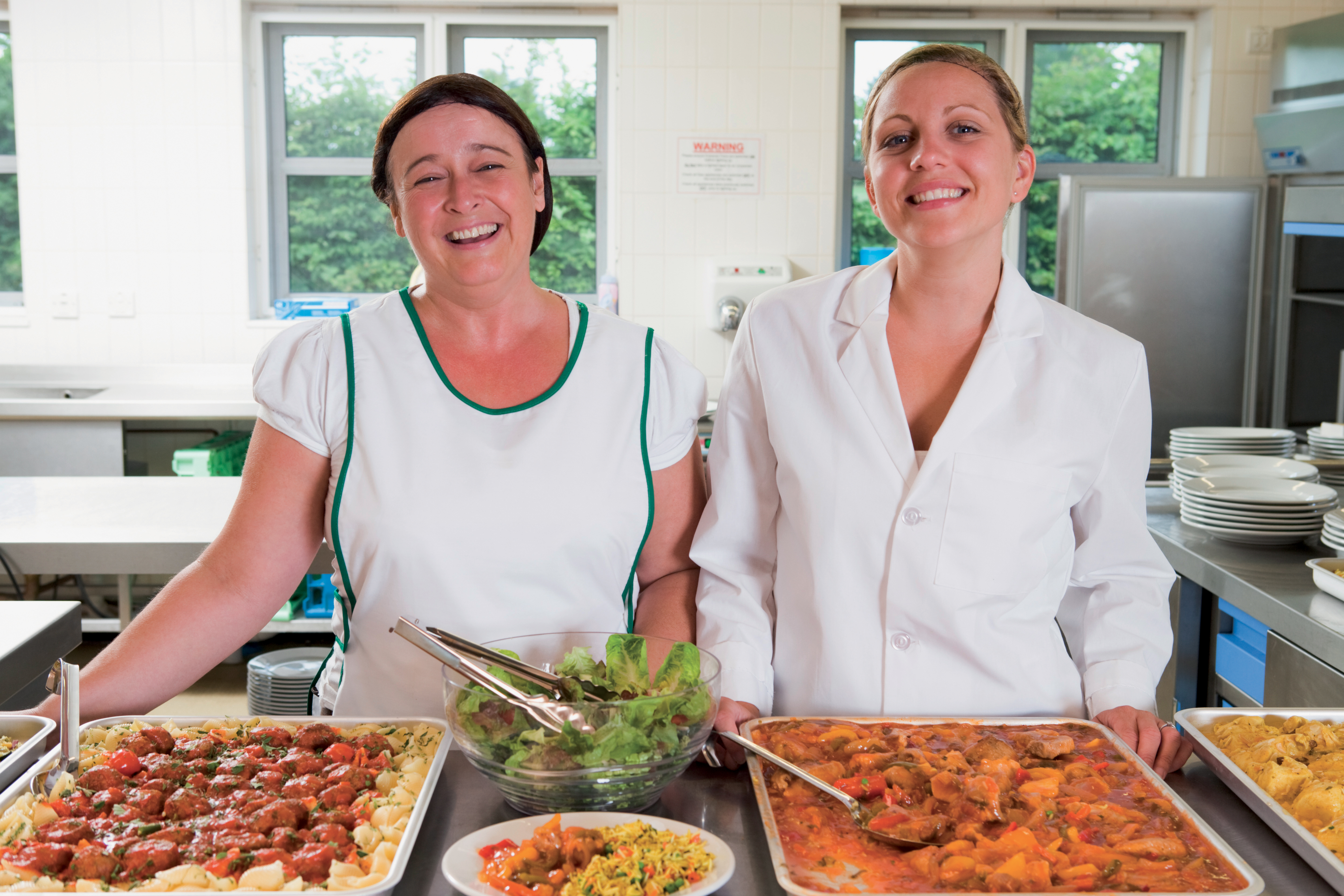 Dinner ladies. Питание в школе. Бесплатным двухразовым питанием. Довольные работники столовой. Школьная столовая стоковые фото.